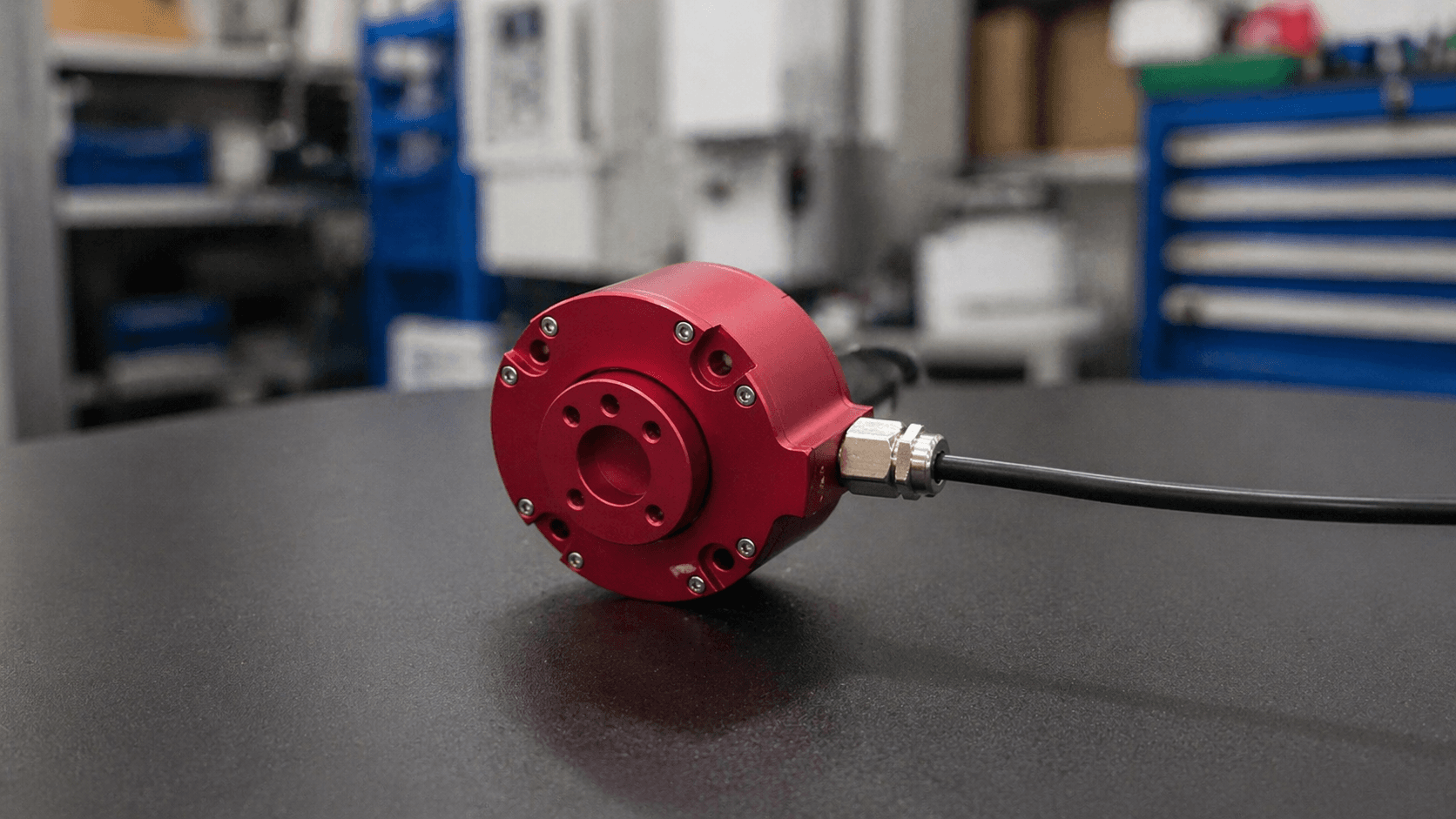 Custom red AXIOM hollow-shaft sensor on a workshop bench
